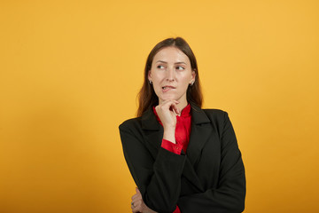 Young Attractive Woman Brunette In Black Stylish Suit, Red Shirt On Yellow Background, Focused...