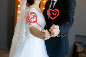 bride and groom holding a red heart