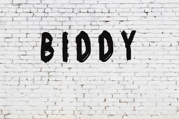 Word biddy painted on white brick wall
