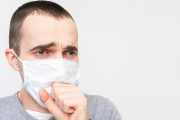 Man in a medical mask coughing, guy is ill, portrait, closeup