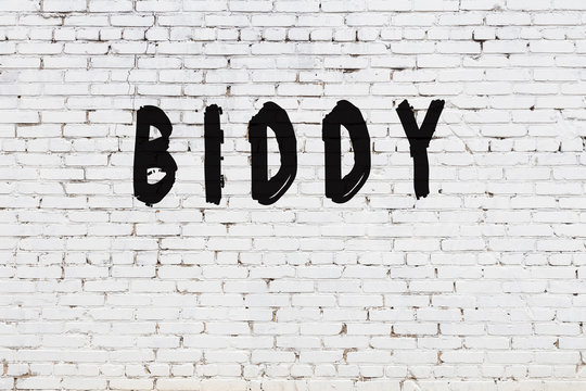 Word biddy painted on white brick wall