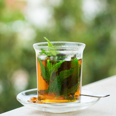 Glass of hot mint tea, traditional moroccan moorish beverage