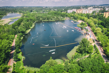 Wake cable park on lake Wakeboarding in the city aerial drone photo 