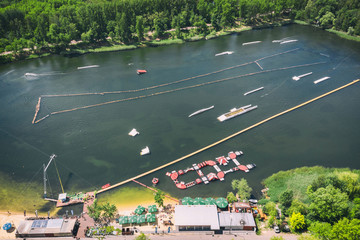 Wake cable park on lake Wakeboarding in the city aerial drone photo 