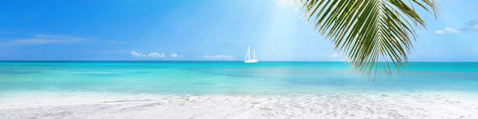 Fototapeta na wymiar Sunny tropical Caribbean beach with turquoise water background, sail boat in lagoon