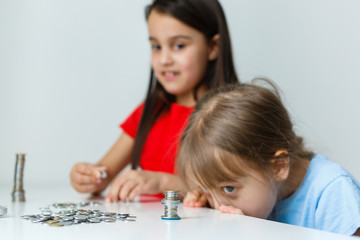 portrait of little girls sitting at table and calculating money