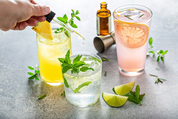 Refreshing summer cocktails with bitters on the table with lime, grapefruit and pineapple