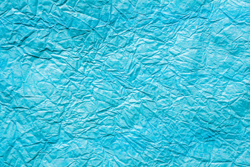 Texture of crumpled blue paper close up. Copy space.