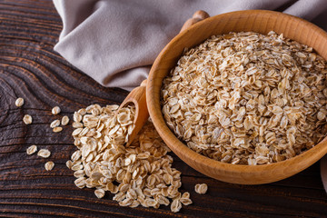 raw oatmeal on a wooden rustic background