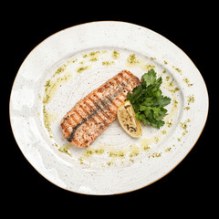 grilled salmon with a slice of lemon on a white plate top photo, isolate, black background
