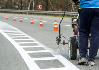 road painting and marking asphalt pavement, seasonal car repair work with the road