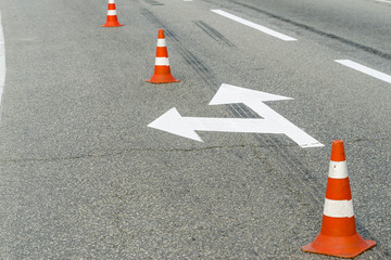 car markings on asphalt with cones, signs for controlling the direction of movement