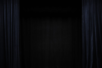 Very dark blue velvet curtain on the sides of a black theatre stage, background frame with large...