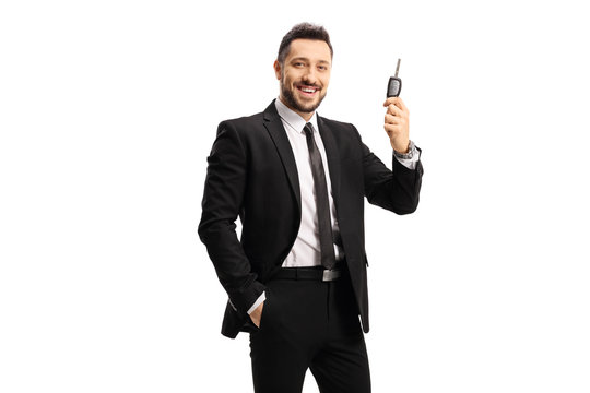 Happy man in a black suit holding a car key