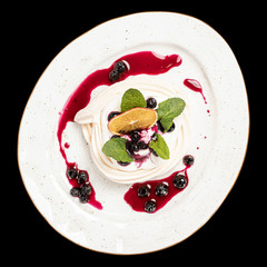 meringue sweet airy dessert with syrup and cherries on a white plate top photo, isolate, black background