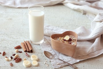 bowl of homemade muesli with nuts, berries, dried fruits, glass of milk and honey. healthy...