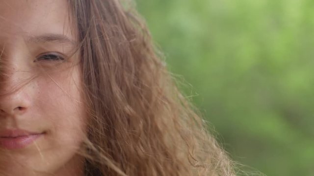 close up half of the face of a teenage girl in a weak wind hair against