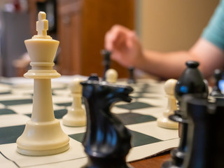 chess board with the white king pinned in the corner and player moving black piece forward