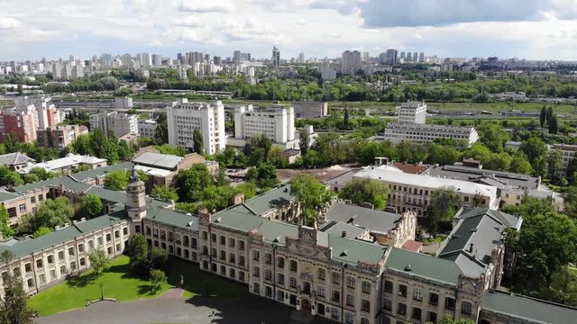 Cityscape old university building aerial clouds drone around movement tilt down brick facade yard Kiev Polytechnic Institute Ukraine