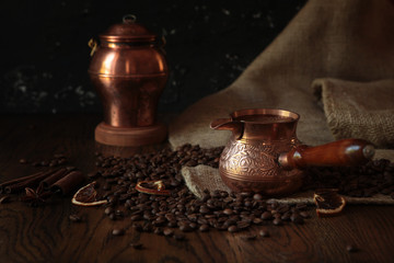 Cezve-traditional cup of coffee, bag and scoop on old rusty background. Dark food photography.