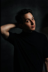 young and handsome man in studio lighting shows emotions