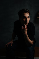 young and handsome man in studio lighting shows emotions