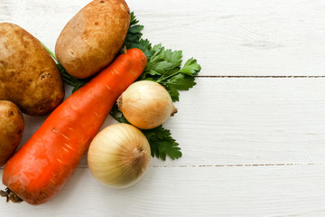 Fresh organic vegetable on the white screen. Carrot, potato, parsley  and onion. Main ingredients for make soup.