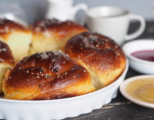 Homemade cake.Buns sprinkled with sesame and sugar syrup with ingredients on a dark wooden table with a gray background.