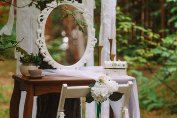 wedding decor close-up white flowers on a chair, preparation of the bride in nature, rustic, tenderness, white