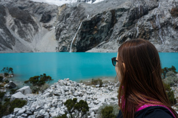 Woman watches the blue waters of Laguna 69, Huascaran, Peru