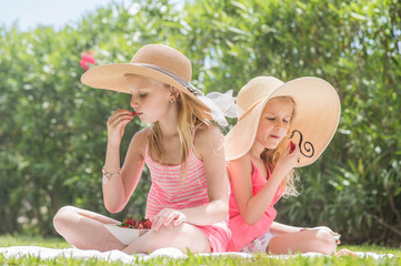 Happy children girls eating strawberries .  Summertime fun