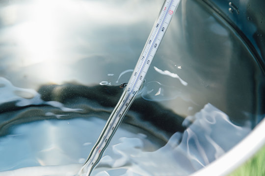 Ein Thermometer steckt in einem Kochtopf beim Erw&auml;rmen f&uuml;r Wasser