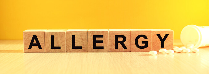 inscription cancer on wooden cubes on a yellow background with pills