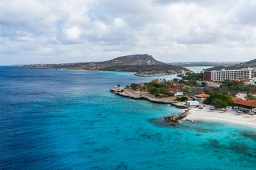 Aerial view of coast of Curacao in the Caribbean Sea with turquoise water, cliff, beach and beautiful coral reef 
