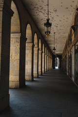 Outdoor corridor with tall arch in a building detail in Girona, Catalonia