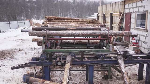 Aerial view of Automated log sorting line. Production of timber from wood. Woodworking. Machining logs. The logs in the sawmill are moving along a conveyor belt