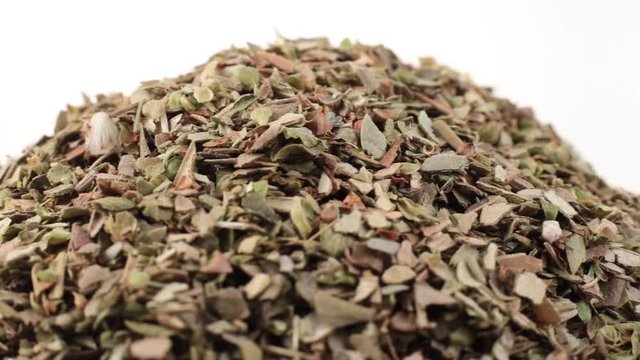 Dry mint grains of spin around themselves on white background