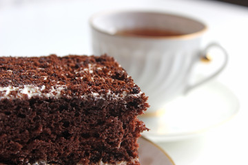 Homemade chocolate brownies with cup of tea on white background, selective focus