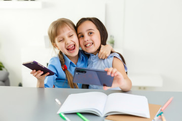Fototapeta premium two little girls studying online. Distance Learning Online, e-learning, concept