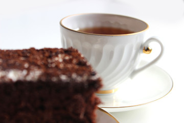 Homemade chocolate brownies with cup of tea on white background, selective focus