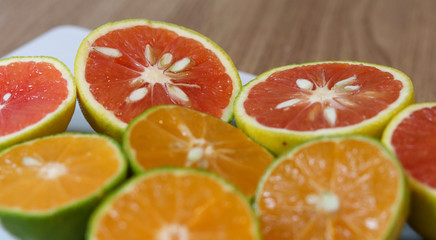 Beautiful lemons and grapefruits cut in half on a cutting board.
