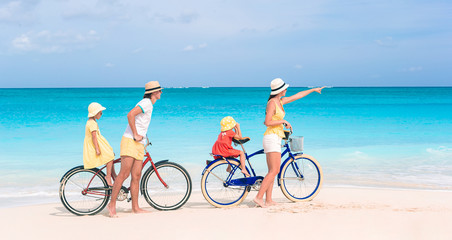 Fototapeta premium Family with a bike on tropical beach