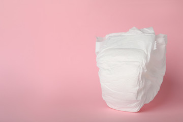 Baby diaper on pink background. Space for text