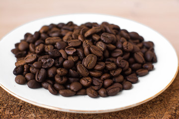 coffee beans on a white plate and cork stand background