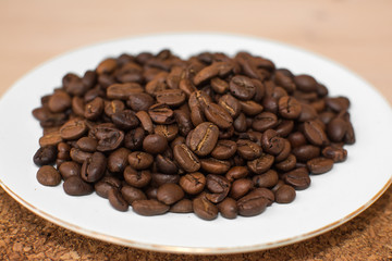coffee beans on a white plate and cork stand background