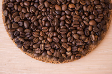 brown coffee beans on a wooden background and cork stand