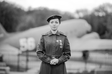 Retro style black and white photography. A young female pilot in uniform of Soviet Army pilots...