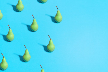 green pear pattern on bright light blue background. Minimal flat lay food texture. Summer abstract trendy fresh concept.