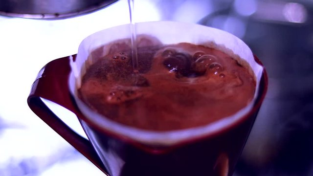 Colocando &aacute;gua quente no coador de caf&eacute; em c&acirc;mera lenta com lindas bolhas se formando
