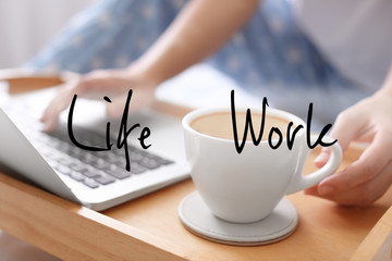 Woman with laptop taking cup of morning coffee indoors, closeup. Concept of balance between work and life